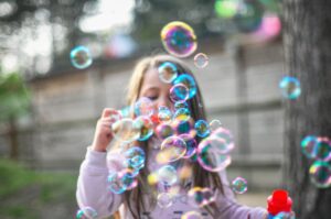 Une petite fille jouant à faire des bulles